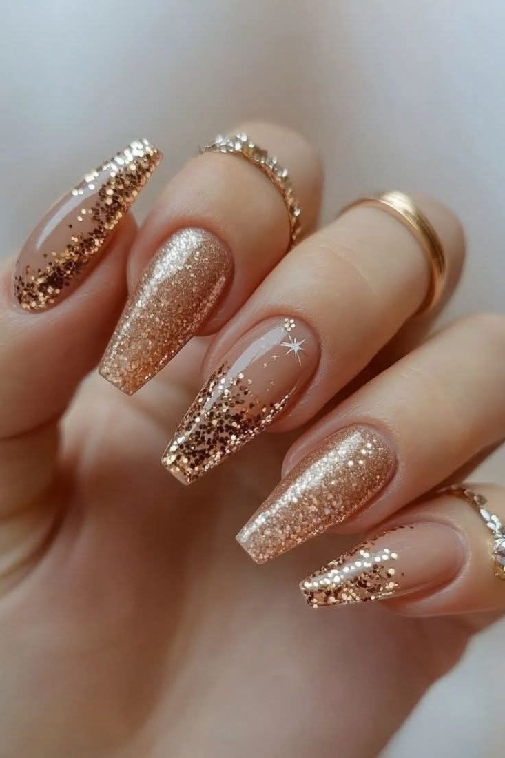 Long nude nails with a gold glitter ombre